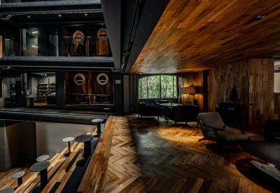 Lobby area with chevron wood flooring and comfortable seating near an atrium.