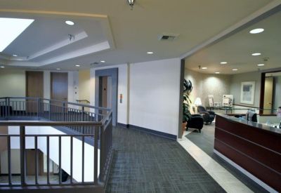 Spacious second-floor lobby area with a dark wood reception desk and elevator access.