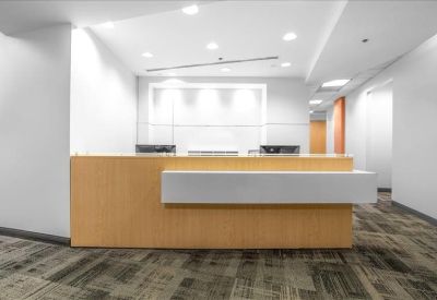 Minimalist reception desk with a light wood finish and clean white background.