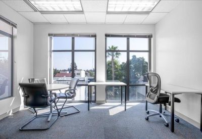 Bright, corner office suite with large windows and modern desks.