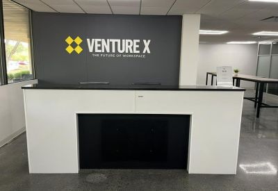 Branded reception area at Venture X Skillman, 23 Orchard Road, Montgomery with a sleek white and black desk.