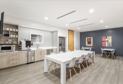 Spacious communal kitchen and dining area with a large white island and colorful wall art.