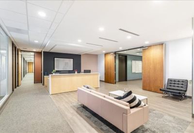 Modern reception lobby featuring a light wood front desk and comfortable lounge seating.