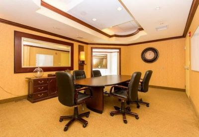 Professional conference room with a large oval table and warm yellow walls.