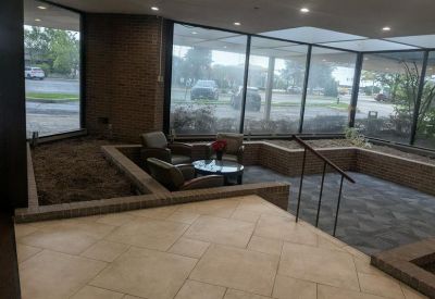 Bright glass-walled common area with comfortable leather armchairs and outdoor views.