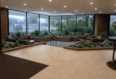 Sun-drenched lobby lounge featuring tile flooring and built-in planters with succulents.