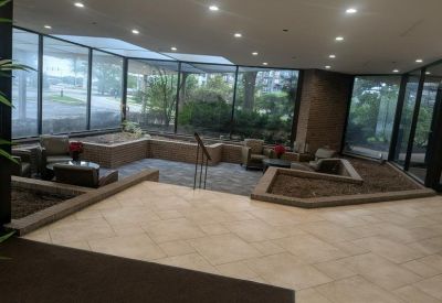Lower-level seating area with stone tile floors and decorative indoor landscaping.
