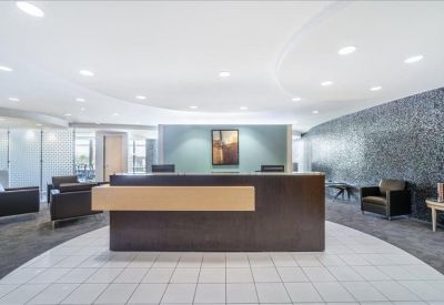 Professional reception area with a dark wood desk and a textured feature wall.