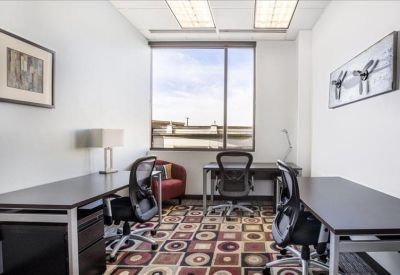 Three-person private office suite with a large window and patterned carpet.