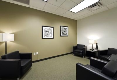 Lounge area with black leather armchairs and contemporary wall art.