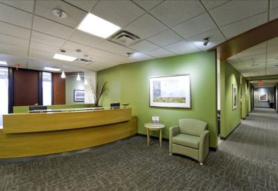 Reception area featuring a curved wooden front desk and a green accent wall.