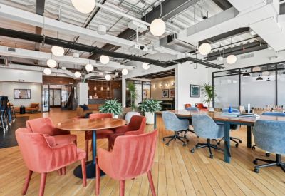 Spacious open-plan lounge area with colorful velvet seating and industrial ceilings.