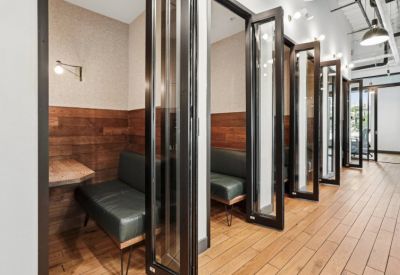 Modern phone booths or private work pods with glass doors and wood paneling.