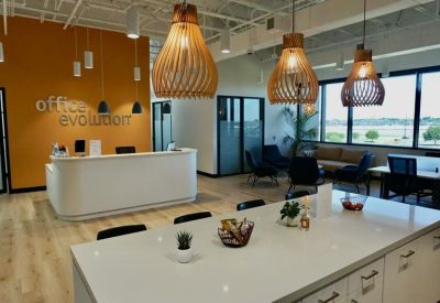 Modern reception area with curved white desk and sculptural wood pendant lights.