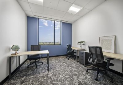 Private three-person office with blue feature wall and large window.