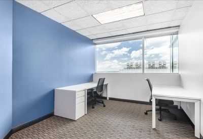 Spacious two-person office with a blue accent wall and large windows.
