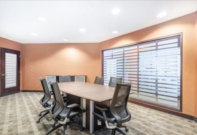 Professional meeting room with warm orange walls and seating for six.