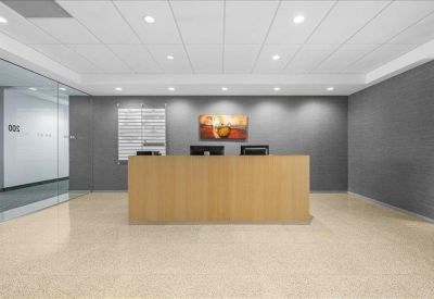 Modern reception area with a wood-panelled desk and branded grey wall.