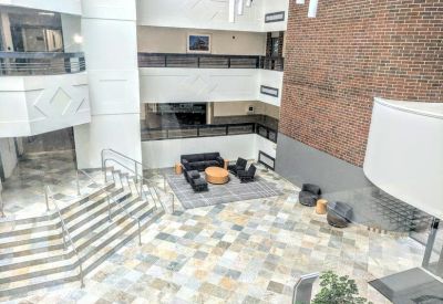 Spacious multi-story atrium lobby at 25, Braintree Hill Office Park, Suite 200 with stone floors and lounge seating.