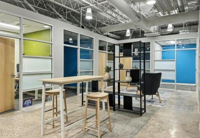 Bright coworking area featuring high-top tables, modern shelving, and blue accent walls.