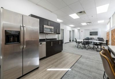 Modern kitchen and breakroom with stainless steel appliances and dark cabinetry.