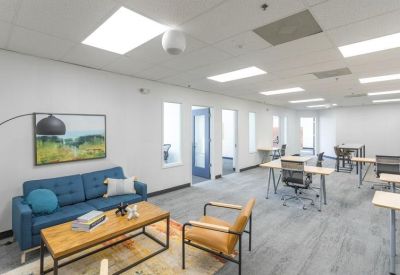 Open-plan coworking area with blue sofa and individual workstations.