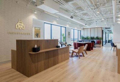 Modern reception area with a slatted wood desk, golden logo, and large windows.