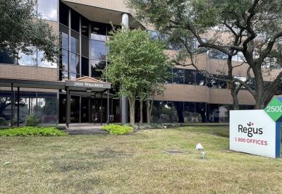 Corner office space with multiple workstations and wrap-around windows.