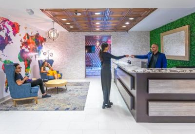 Modern reception desk with a vibrant world map mural and seating area.