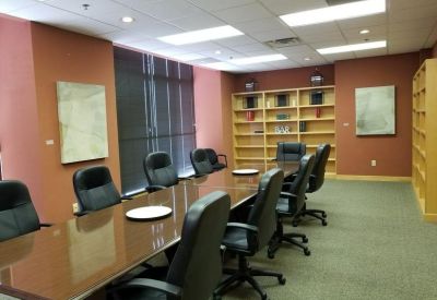 Spacious boardroom with a long polished table and wall-to-wall bookshelves.