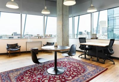 Private office space with wooden floors, a small meeting table, and city views.