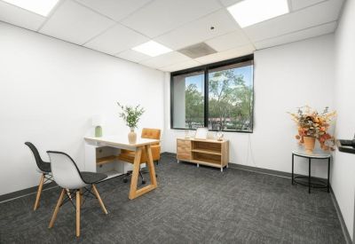 Private office featuring a minimalist white desk and a large window.