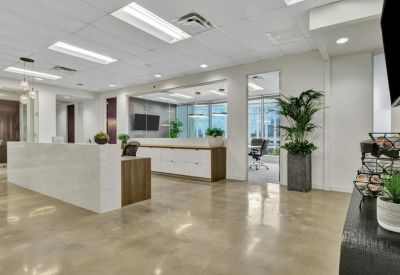 Sleek reception area featuring a white marble desk and polished concrete floors.