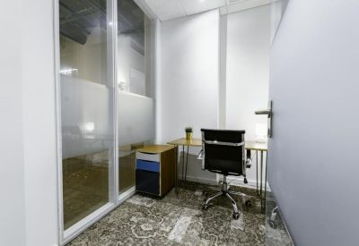 Single-person private office with a frosted glass partition and wood-top desk.