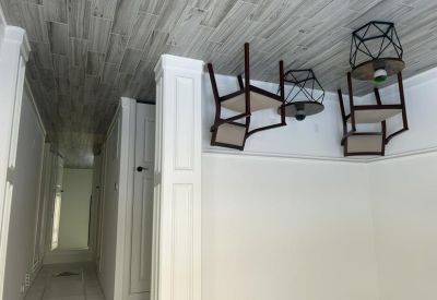 Internal hallway showing stylish geometric pendant lights and wooden chairs.