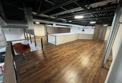 Lounge area on a wooden mezzanine overlooking the lower office floor.