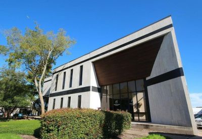 Angular building exterior featuring large glass windows and a prominent wood-lined overhang.