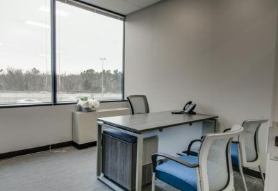Private office with a large window and a guest chair.