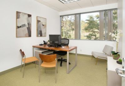 Simple private office with a wooden desk and two guest chairs.