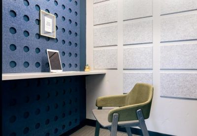 Sound-dampened focus room with blue acoustic panels and a small desk.