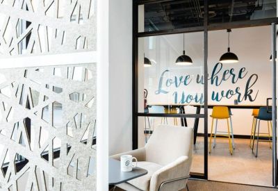 Modern office interior with a yellow accent wall and built-in booth seating.