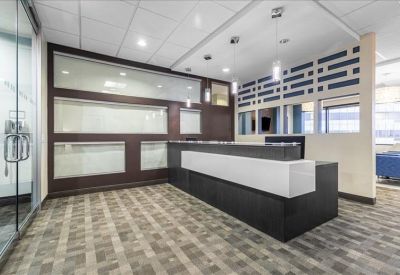 Contemporary reception area featuring a black and white front desk and pendant lighting.