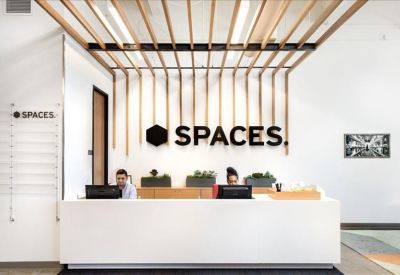 Sleek white reception desk with wooden ceiling slats and branded logo backdrop.