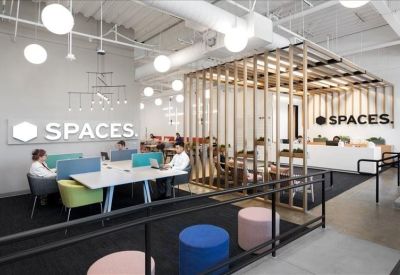 Open-plan workspace with a wooden slat partition and branded signage on the wall.