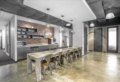 Communal break area with a long rustic wooden table and industrial brick accents.