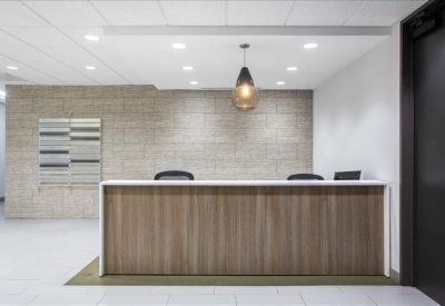 Professional reception desk with wood paneling and a modern pendant light.