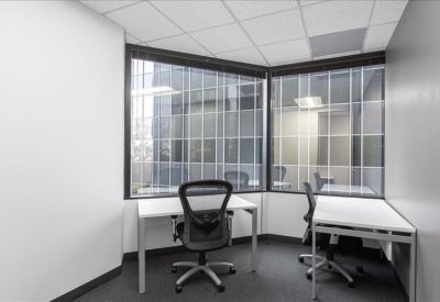 Dual workstation office suite with ergonomic chairs and large windows.
