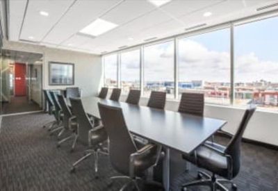 Large boardroom with a sleek dark table, black leather chairs, and floor-to-ceiling windows.