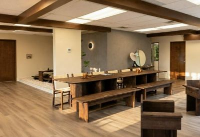 Open communal area with a long rustic wooden table and benches under exposed beams.