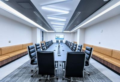 Large boardroom with black leather chairs and modern recessed ceiling lights.